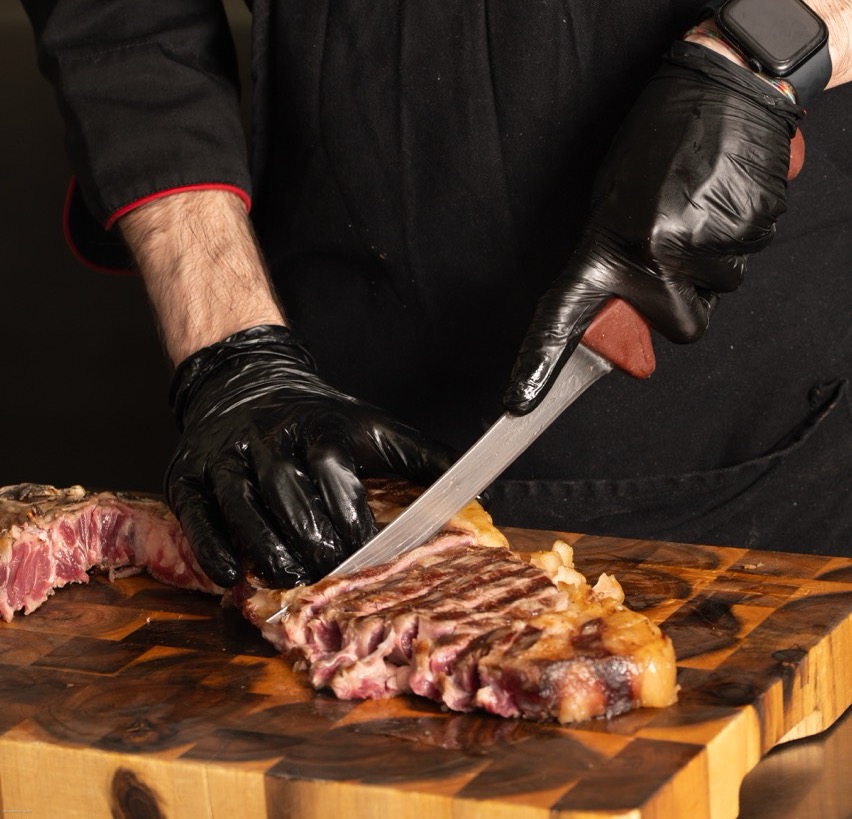 Komos chef presenting perfectly sliced steak